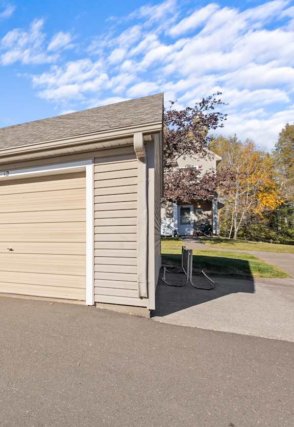 A long building with a grey roof and tan garage doors.