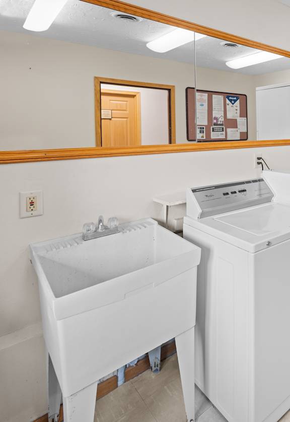 A white sink and a white cabinet are in a room.