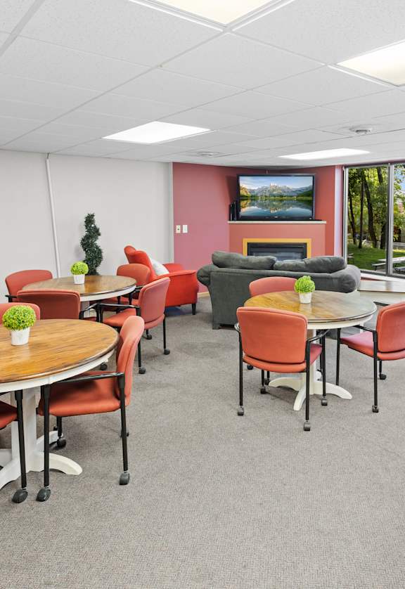 A conference room with a table surrounded by chairs.