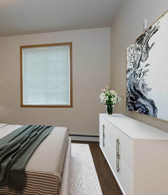 a bedroom with a large bed and a window. Fargo, ND North Sky Apartments