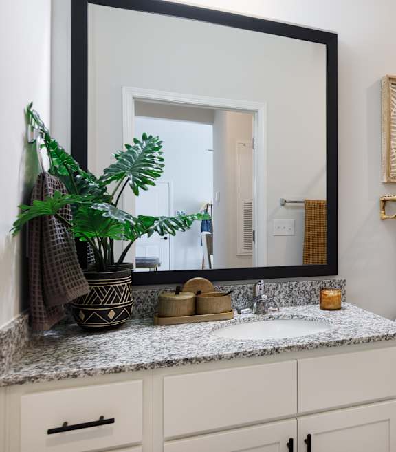 A bathroom with a toilet, sink, and mirror.