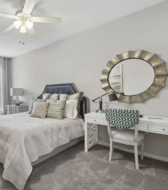 A bedroom with a large bed and a ceiling fan.