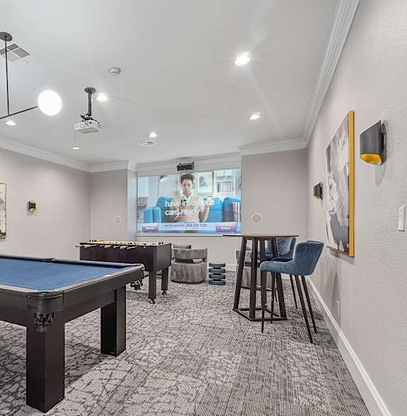 A room with a pool table and a television.