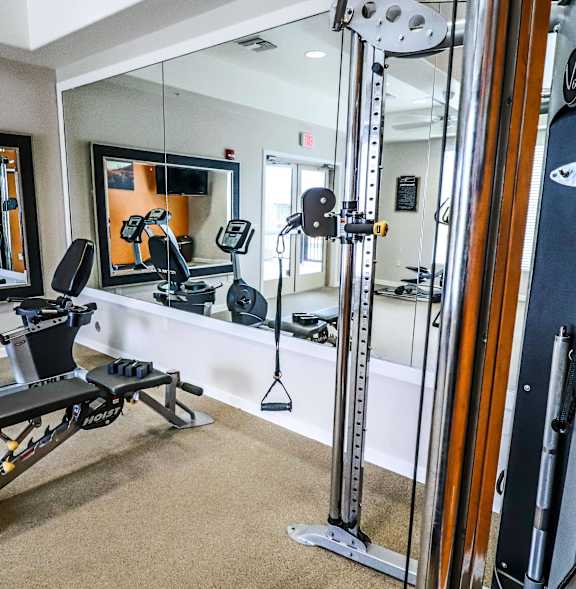 A gym with treadmills, a bench, and a weight machine.