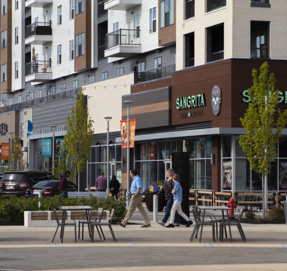people walking down a street in front of buildings at Slate at Fishers District, Fishers, IN