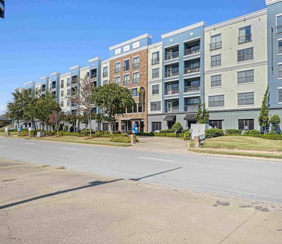 A row of modern apartment buildings are lined up on a street.