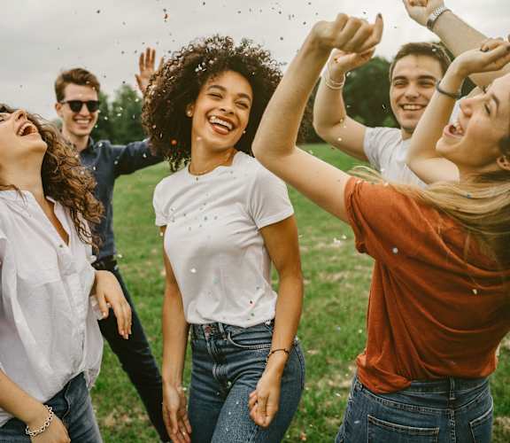 a group of young people laughing in a field
