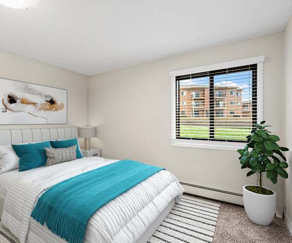 A bedroom with a large bed and a potted plant.