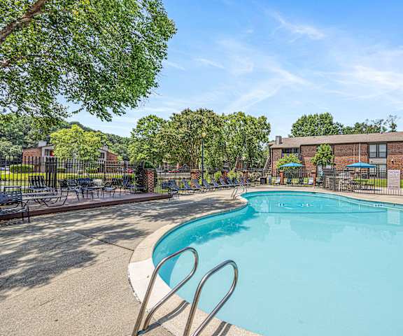 A large swimming pool surrounded by trees and a fence.