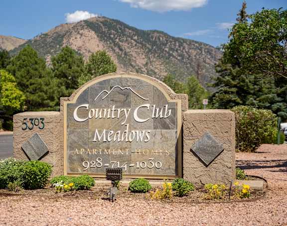 A sign for Country Club Meadows with a phone number on it.