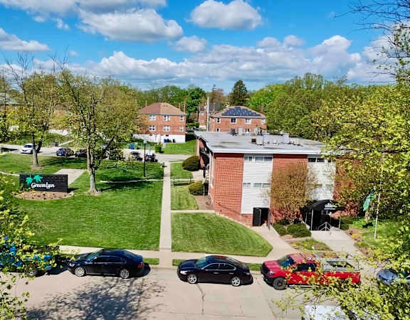 an aerial view of a neighborhood with cars parked on the street