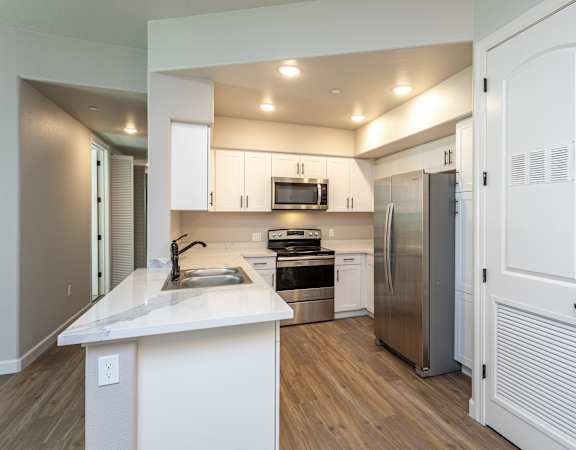 a kitchen with white cabinets and stainless steel appliances