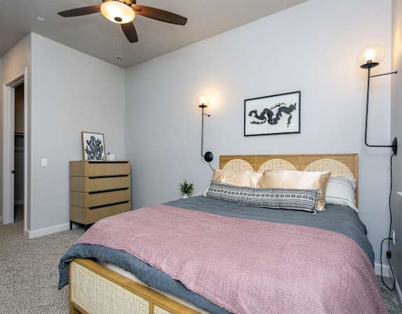 a bedroom with a bed and a ceiling fan