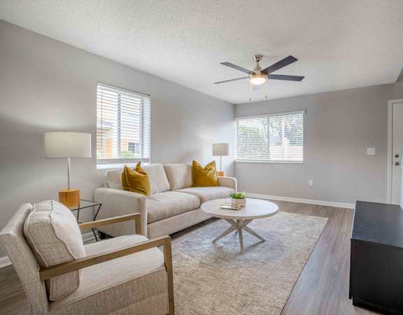 a living room with a couch and a ceiling fan