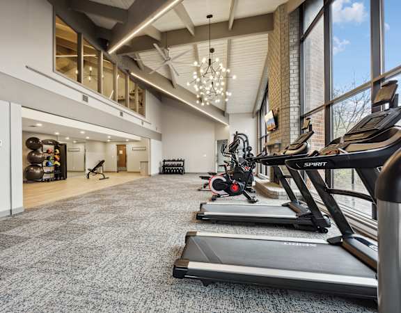 a gym with treadmills and other exercise equipment in the lobby of a building