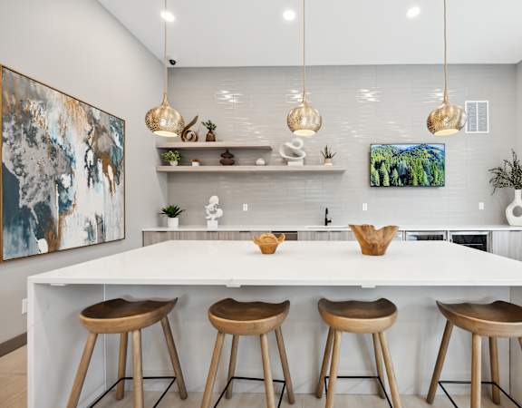 a kitchen with a large island and four wooden stools