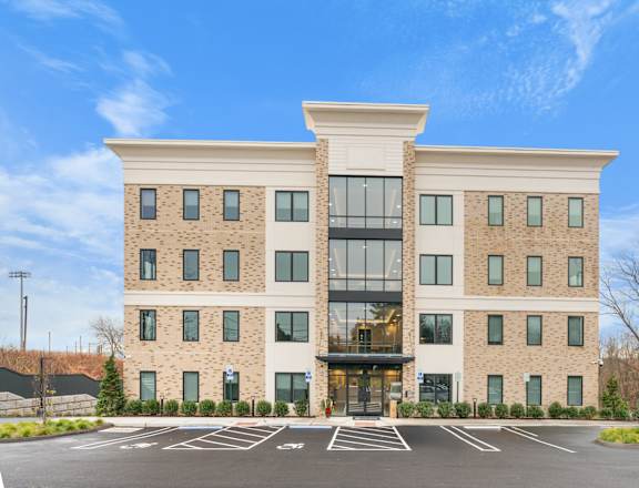 A large building with a parking lot in front.