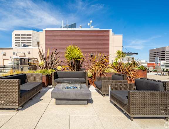 A patio with a table and chairs surrounded by plants.