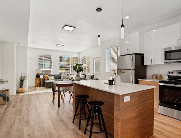 a kitchen and living room with an island and stools