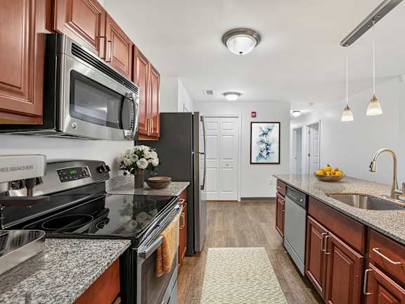 A living room with a fireplace and a painting on the wall.at Glenmont Abbey Village, 55+ Apartments, New Jersey, 12077