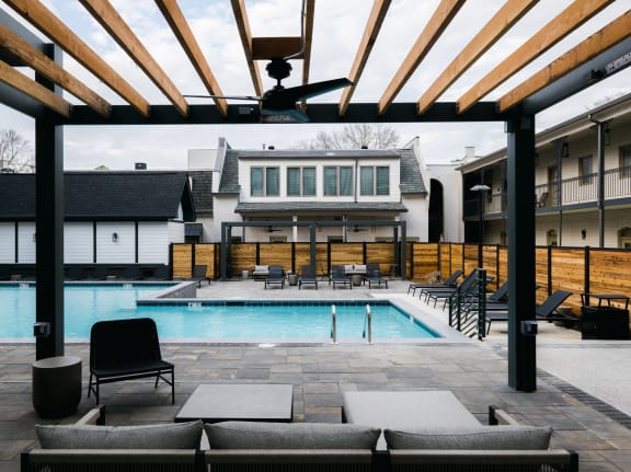 Pool with lounge chairs and a ceiling fan under a pergola at The Quarter House, Jackson, MS