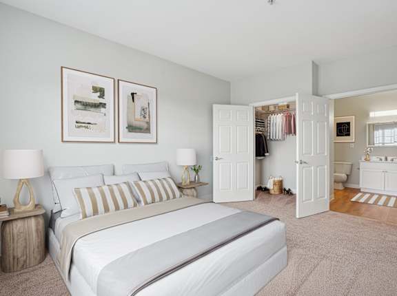 A bedroom with a large bed and two lamps.