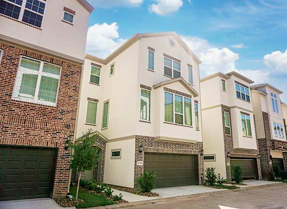a row of townhomes with brown garage doors