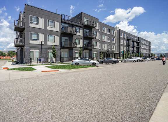 Apartment building with cars parked in front.