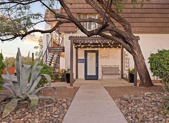A building with a blue door and a sign that says "Zona Vllage".