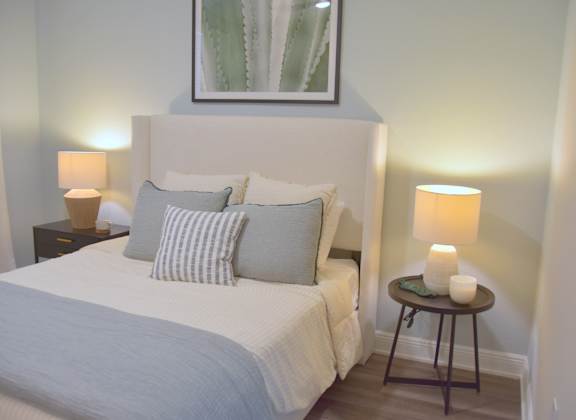 a bedroom with a bed and two lamps