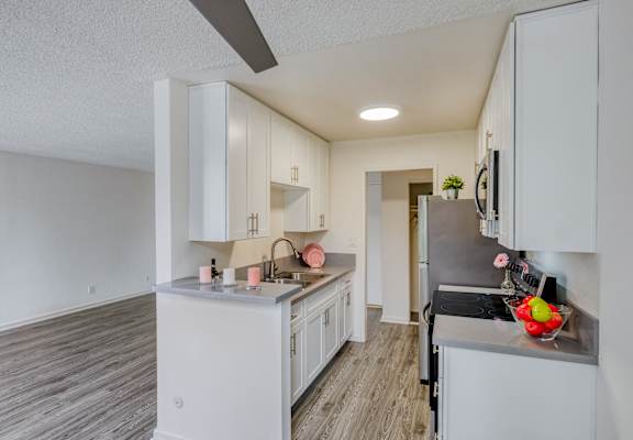 a renovated kitchen with white cabinets and a large counter top