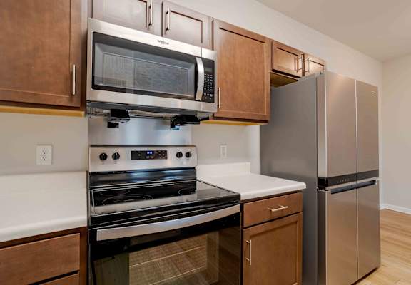 A kitchen with a stainless steel refrigerator and a black oven.