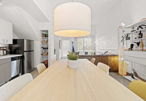 a dining room with a wooden table and white chairs