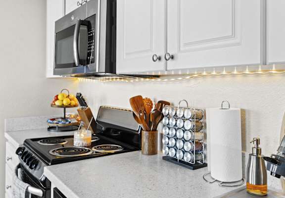 a kitchen with a stove and a counter with a roll of paper towels on it