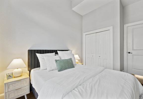 a bedroom with a white bed and a white door