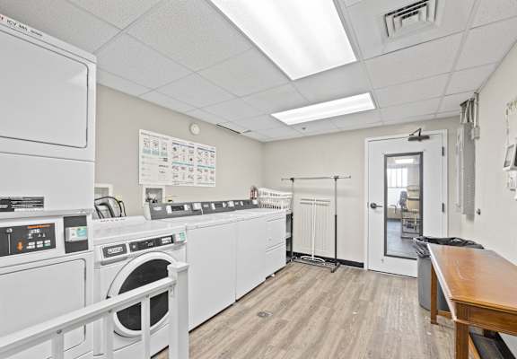 a laundry room with a washer and dryer and a table and a door