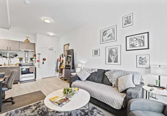 a living room with a gray couch and a white table