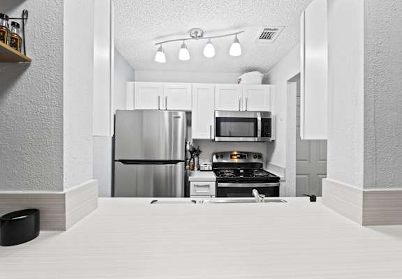 a kitchen with stainless steel appliances and white cabinets