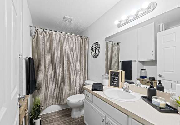 a bathroom with a shower and a sink and a toilet