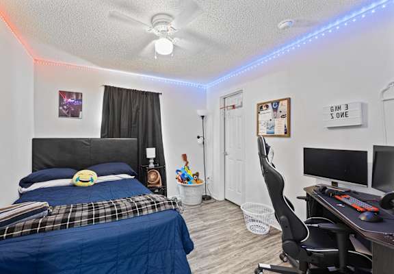 a bedroom with a bed and a desk and a tv