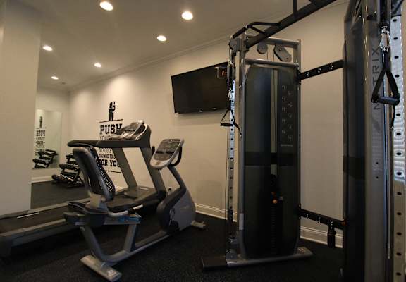 a home gym with exercise equipment and a tv
