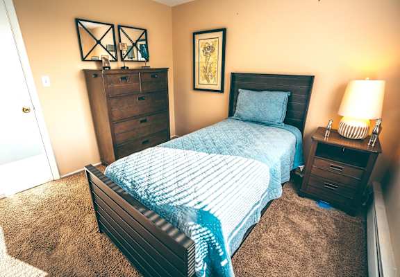 a bedroom with a bed and a dresser and a door