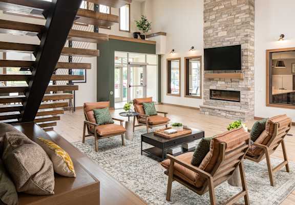 A living room with a stone fireplace and a TV mounted above it. at The Edison at Rice Creek I and II, Minnesota, 55126