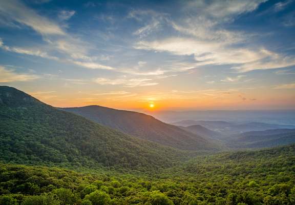 the sun setting over the mountains of the great smoky mountains