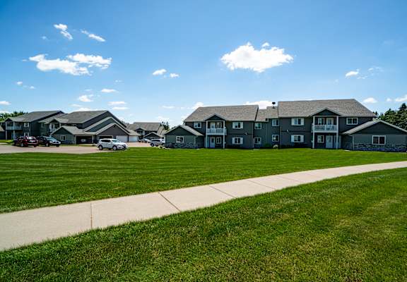 A row of houses with a sidewalk in front.