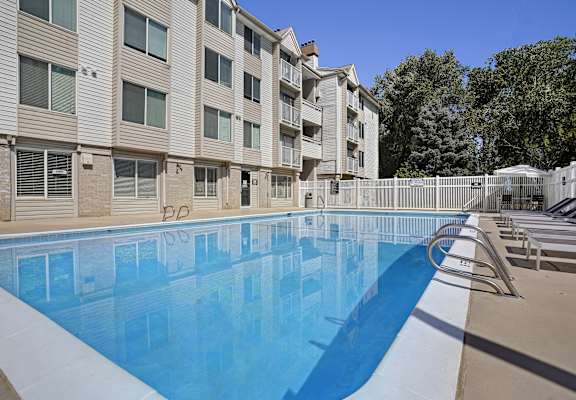 A large swimming pool in front of apartment buildings.