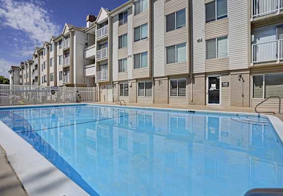 A swimming pool in front of apartment buildings.