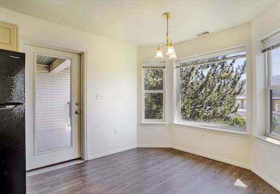A room with a door, a window, and a chandelier.