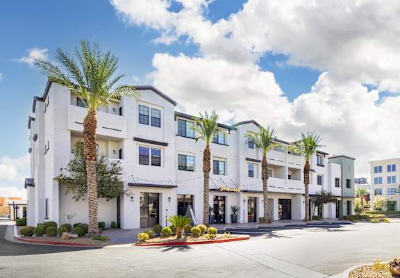 a large white building with palm trees in front of it