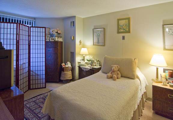 a bedroom with a bed and a teddy bear
